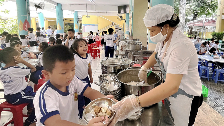 Bữa ăn bán trú: trách nhiệm của ai? - Ảnh 1. Học sinh tiểu học ở quận 1, TP.HCM trong bữa trưa tại trường - Ảnh: MỸ DUNG